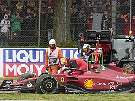 Odklízení monopostu Carlose Sainze z Ferrari po nehod v úvodu Velké ceny...