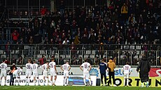 Sparťanští fotbalisté zahanbeně stojí před svými fanoušky po porážce v Olomouci.