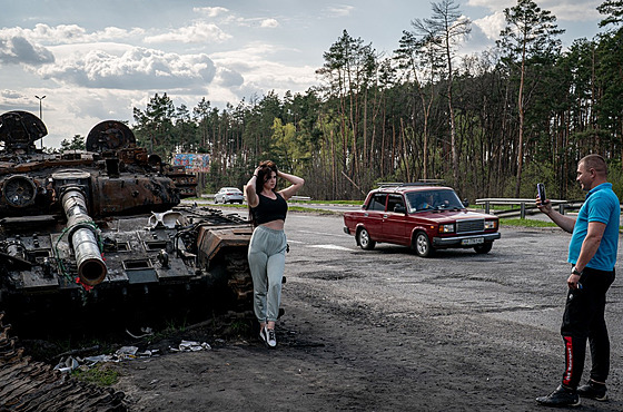 ena pózuje u znieného ruského tanku poblí Makarivu v Kyjevské oblasti. (2....