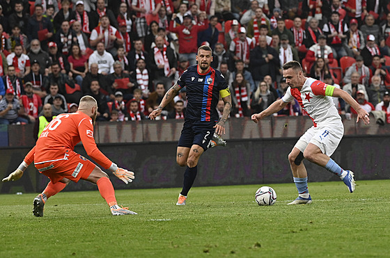 Stanislav Tecl (vpravo) ze Slavie v zajímavé stelecké pozici sleduje brankáe...