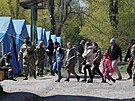 Civilisté z oblasti ocelárny Azovstal v Mariupolu prochází v doprovodu lena...