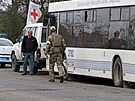 Voják proruské hlídky kráí vedle autobusu s civilisty evakuovanými z oblasti...