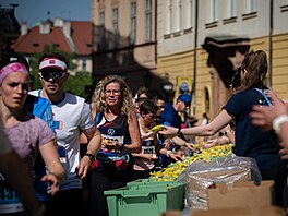 Obsluha oberstvovací stanice nabízí banány probíhajícím závodníkm Praského...