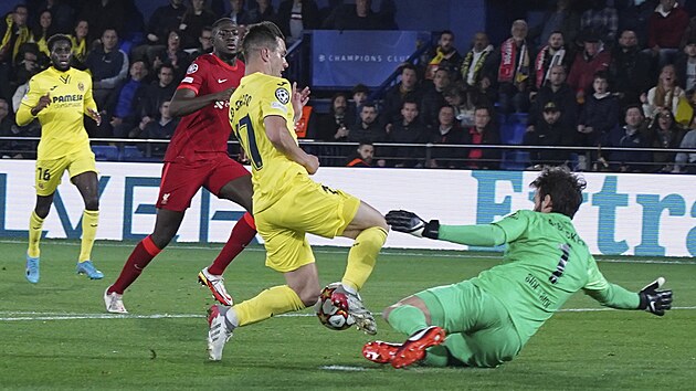 Giovani Lo Celso  (Villarreal) se sna na posledn chvli vyhnout branki Alissonovi (Liverpool).