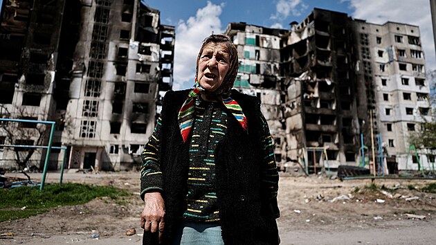 Žena z Borodjanky stojí před budovou zničenou ostřelováním. (2 května 2022)