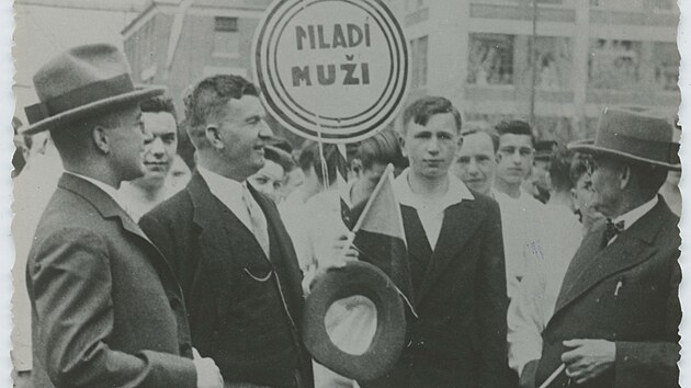 Tom Baa s Dominikem iperou (vlevo) a lkaem Rudolfem Gerbecem ped skupinou mladch mu na seaditi v tovrnm arelu (1930)