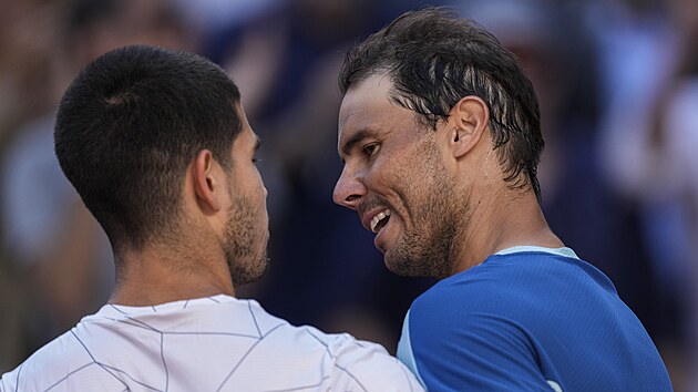 Rafael Nadal (vpravo) gratuluje v Madridu svmu pemoiteli Carlosi Alcarazovi.