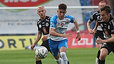Petr Jaro� z Baníku Ostrava (uprost�ed) v souboji o mí� proti dv�ma protihrá��m...