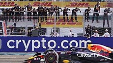 Mechanici Red Bullu slaví v moment, kdy Max Verstappen projídí vítzn cílem...