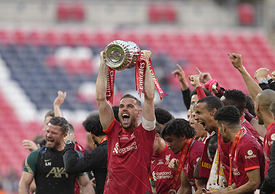 Liverpoolský kapitán Jordan Henderson zvedá nad hlavu trofej pro vítze FA Cupu.