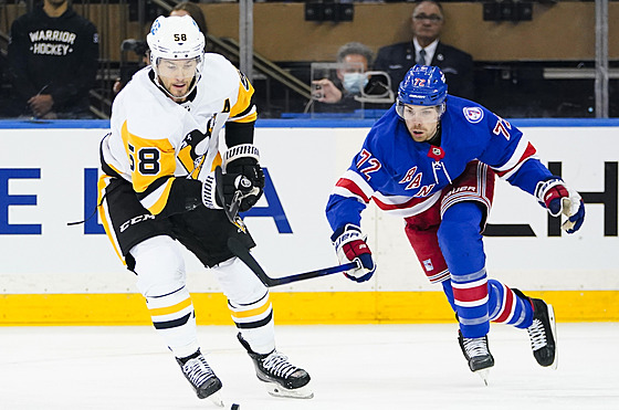 Kris Letang (58) z Pittsburgh Penguins se snaí ujet, stíhá ho Filip Chytil...