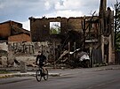 Chlapec projídjící kolem znieného domu v ukrajinské Bui (17. kvtna 2022)