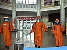 Pracovníci dezinfikují podlahu stanice metra v Pchjongjangu. (17. kvtna 2022)