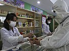 Zamstnanci lékárny v Pchjongjangu prodávají léky zatímco se zemí íí...
