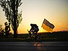 Mu na kole s ukrajinskou vlajkou jede na silnici mezi Odsou a Mykolajivem na...