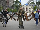 Ukrajinský voják jede na elektrokolobce ped protitankovými zábranami v...