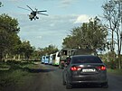 Ruský vojenský vrtulník nad kolonou autobus s ukrajinskými vojáky evakuovanými...