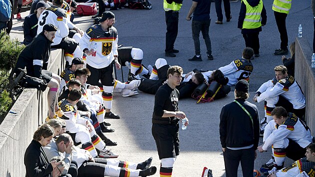 Němečtí hokejisté čekají před halou v Helsinkách, až jim hasiči a bezpečnostní...