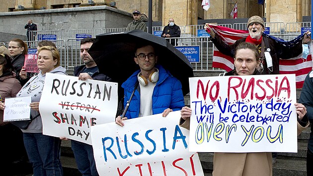 Demonstranti drží transparenty během protestu proti ruské invazi na Ukrajinu v gruzínském Tbilisi. (8. května 2022)