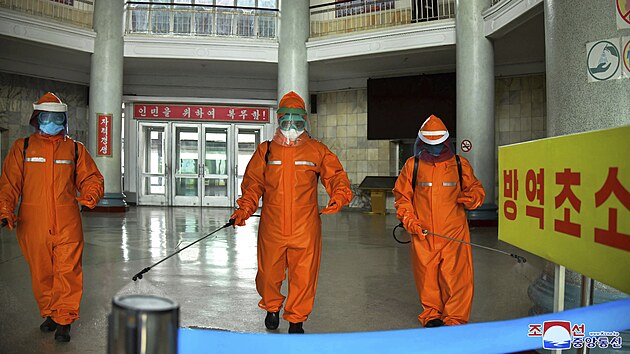 Pracovníci dezinfikují podlahu stanice metra v Pchjongjangu. (17. května 2022)