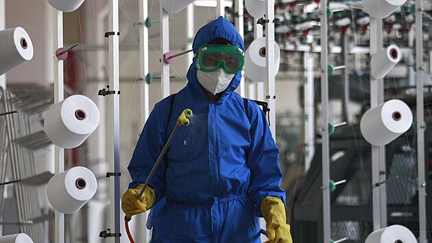 Pracovník dezinfikuje továrnu v Pchjongjangu. (18. května 2022)