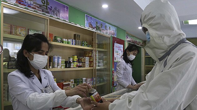 Zaměstnanci lékárny v Pchjongjangu prodávají léky zatímco se zemí šíří covid-19. (15. května 2022)