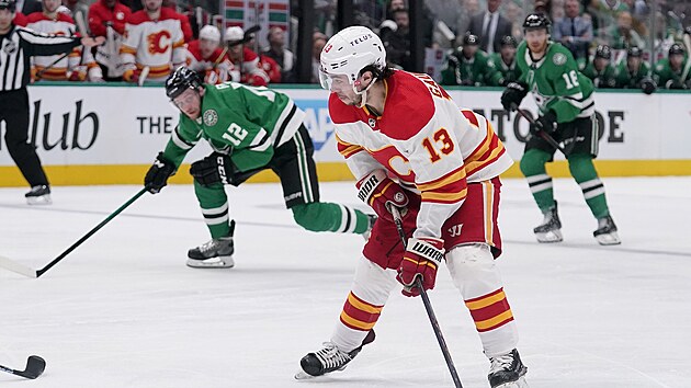 Johnny Gaudreau (v poped) z Calgary sleduje dn ped sebou, ze strany ho kontroluje Radek Faksa (vlevo) z Dallasu.