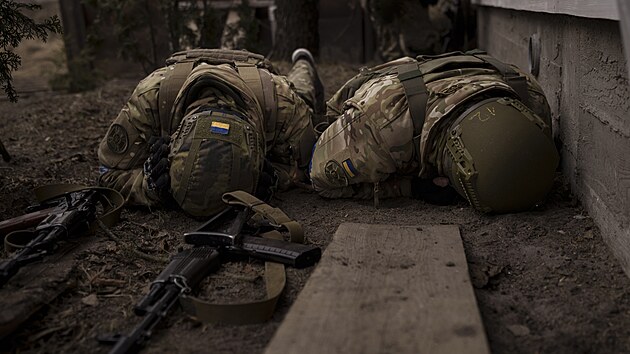 Ukrajintí vojáci se kryjí ped dlosteleckou palbou v Irpini. (13. kvtna...
