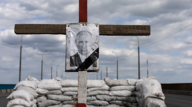 Portrét ruského prezidenta Vladimira Putina na jeho symbolickém hrobu u kontrolního stanoviště v Dněpru  (10. května 2022)