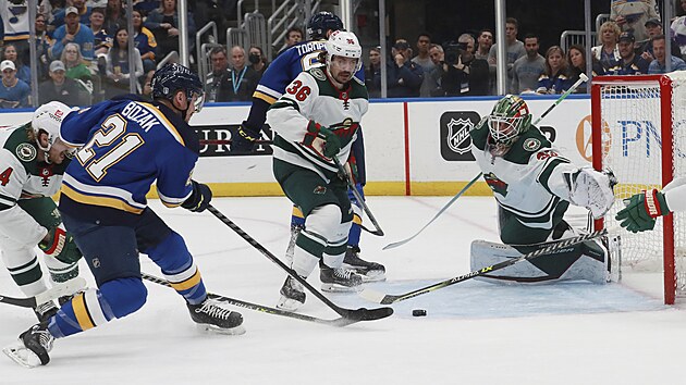 Tyler Bozak (21) ze St. Louis Blues skruje v zpase s Minnesota Wild, pekonanm je Cam Talbot.