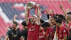Liverpoolský kapitán Jordan Henderson zvedá nad hlavu trofej pro vítěze FA Cupu.