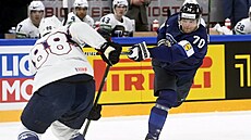 Finský úto�ník Teemu Hartikainen (70) pálí kolem amerického beka Natea Schmidta...