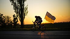 Mu na kole s ukrajinskou vlajkou jede na silnici mezi Odsou a Mykolajivem na...