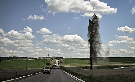 Reportéi agentury AFP zachytili dramatický prjezd po ostelované silnici...