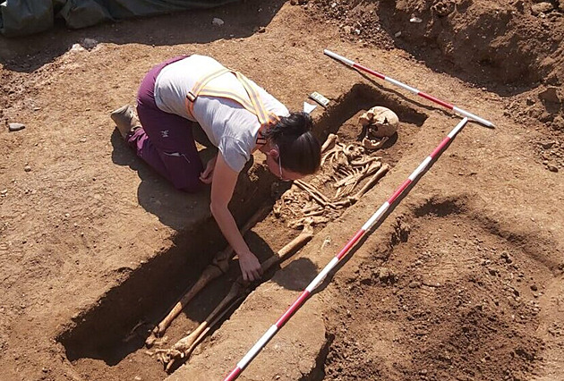 Archeologové našli pod silnicí stovky koster, kruhové objezdy musejí počkat