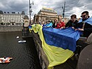 Lid vyvsili na praskm most Legi vlajky Ukrajiny a EU jako vyjden...