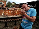 Mu zapalující si cigaretu ped znieným ruským tankem v Charkovské oblasti...