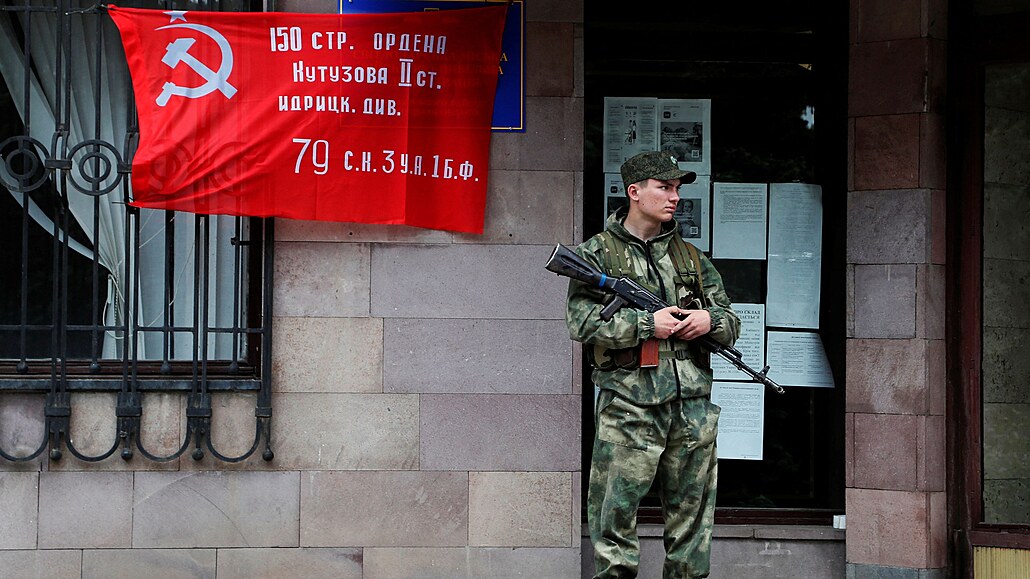 Před budovou městské civilní vojenské správy v Doněcku stojí na stráži voják...