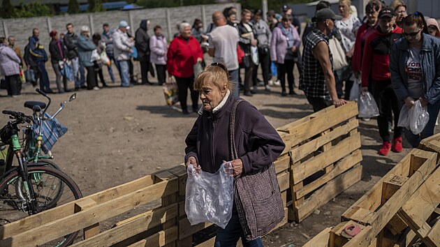 Lidé v Charkově stojí ve frontě na potraviny. (23. května 2022)