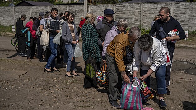 Lidé v Charkově stojí ve frontě na potraviny. (23. května 2022)