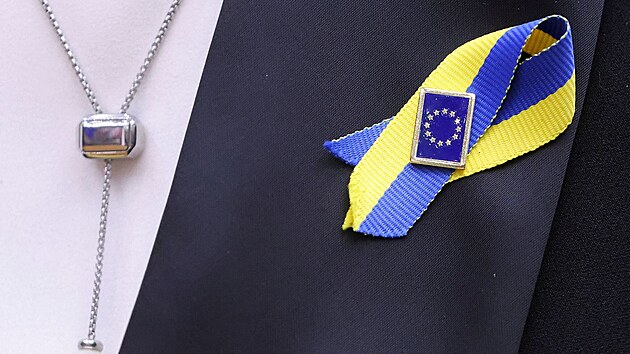 len Evropskho parlamentu se stukou v barvch ukrajinsk vlajky a pendlkem s vlajkou Evropsk unie (1. bezna 2022)