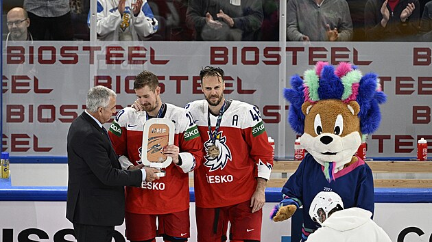 Čeští útočníci Roman Červenka (10) a David Krejčí (46) přebírají bronzovou plaketu od šéfa Mezinárodní hokejové federace (IIHF) Luca Tardifa.