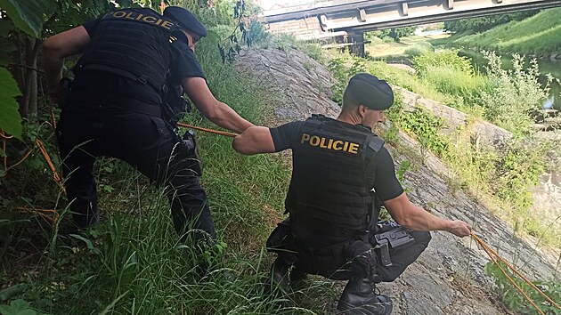 Policisté v Novém Jičíně vytahují pomocí lana dvě ženy, které se topily v řece Jičínce. (21. května 2022)