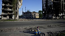 Chlapec si hraje před domy zničenými ostřelováním v Boroďance na Ukrajině. (24....