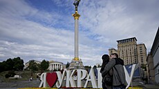 Pár mladých lidí se líbá v centru Kyjeva na Ukrajin. (25. kvtna 2022)