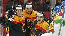 Německý hokejista Kai Wissmann (uprostřed) slaví se spoluhráči Moritzem...