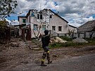 Voják ukrajinské jednotky Kraken prochází kolem znieného domu ve vesnici Ruska...