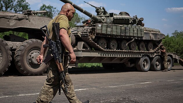Ukrajinský voják je poblíž vojenského náklaďáku s tankem na silnici v Doněcké oblasti na Ukrajině. (8. června 2022)