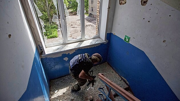 Rusk vojk kontroluje budovy koly ve mst Marinka  v Donck oblasti. (31. kvtna 2022)