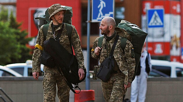 Territorial Defence members Oleksandr Zhygan, 37, and partner Antonina Romanova, 37, arrive at a train station to depart for the frontline, as Russia's attack on Ukraine continues, in Kyiv, Ukraine May 25, 2022.